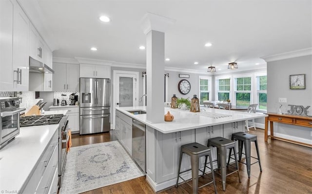 kitchen featuring white cabinetry, stainless steel appliances, a center island, and sink