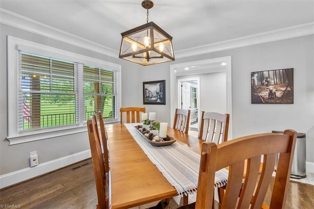 dining space featuring ornamental molding, an inviting chandelier, and dark hardwood / wood-style floors