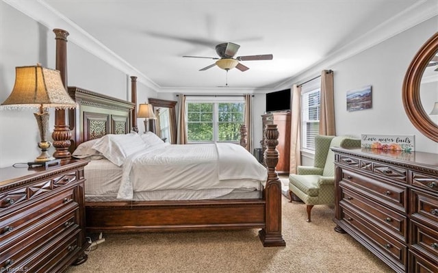 carpeted bedroom with ornamental molding and ceiling fan