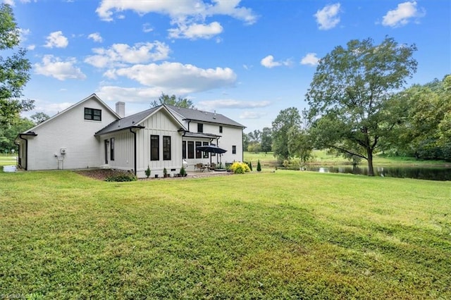 back of property featuring a yard and a water view