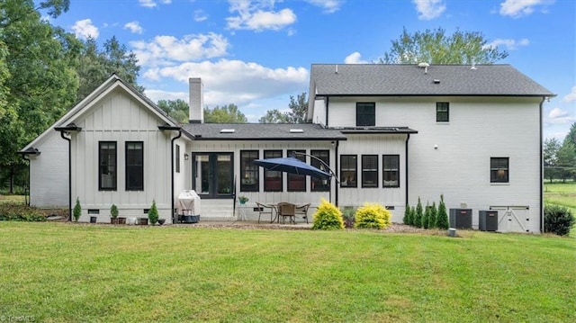 rear view of property with a yard, a patio area, central AC unit, and a sunroom