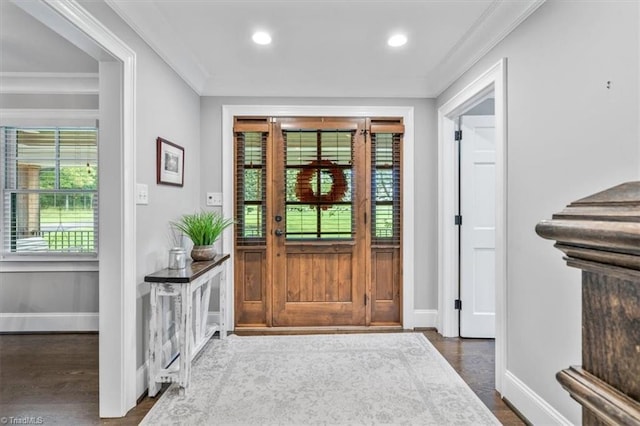 entryway with ornamental molding and dark hardwood / wood-style flooring