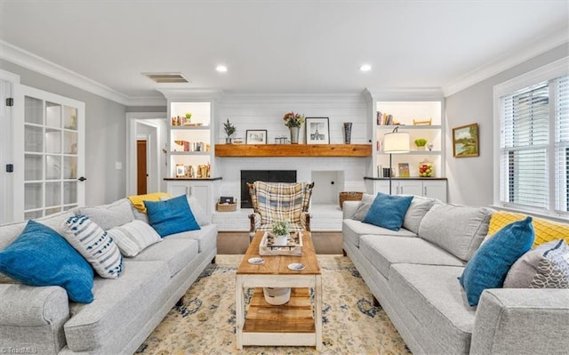 living room with hardwood / wood-style floors, a fireplace, and crown molding