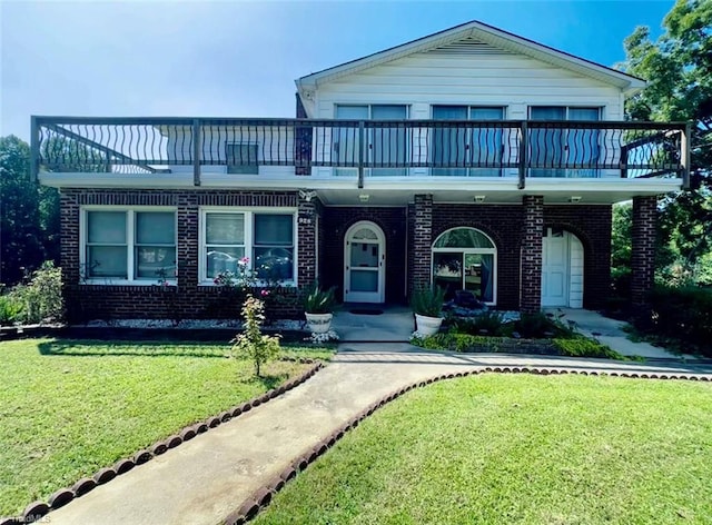 view of front of property with a balcony and a front lawn