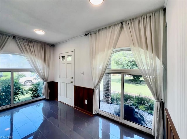 entrance foyer featuring dark tile patterned flooring and a wealth of natural light