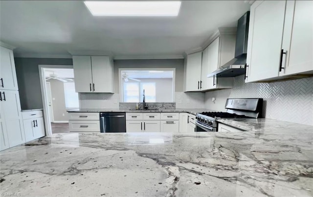 kitchen with light stone counters, stainless steel appliances, and wall chimney range hood