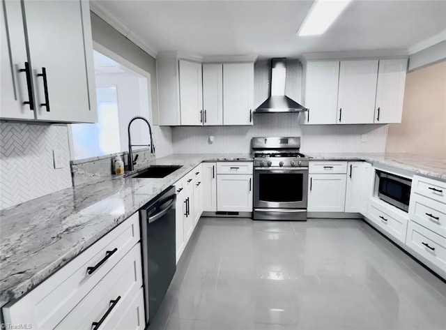 kitchen with white cabinetry, light stone countertops, stainless steel appliances, sink, and wall chimney range hood