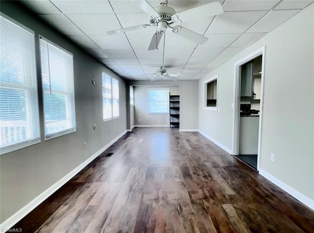 empty room featuring wood-type flooring, ceiling fan, and a paneled ceiling