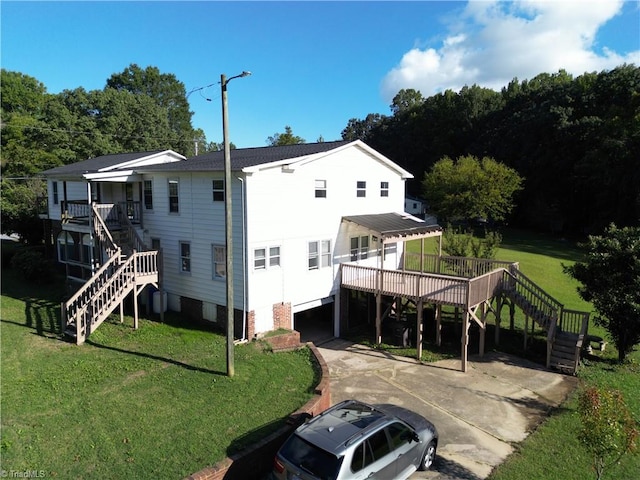 rear view of house with a lawn and a wooden deck