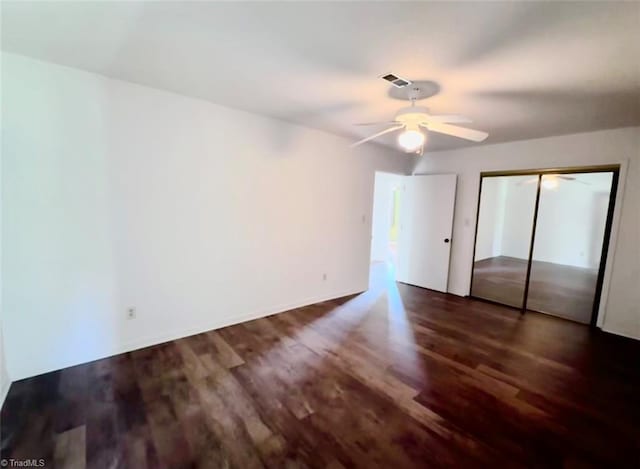 unfurnished bedroom featuring a closet, ceiling fan, and dark wood-type flooring