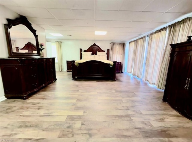 bedroom featuring a drop ceiling and light wood-type flooring