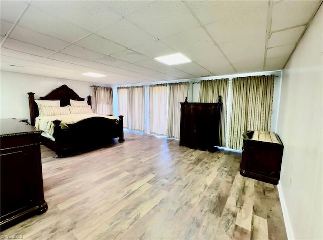 bedroom featuring light hardwood / wood-style flooring and a paneled ceiling