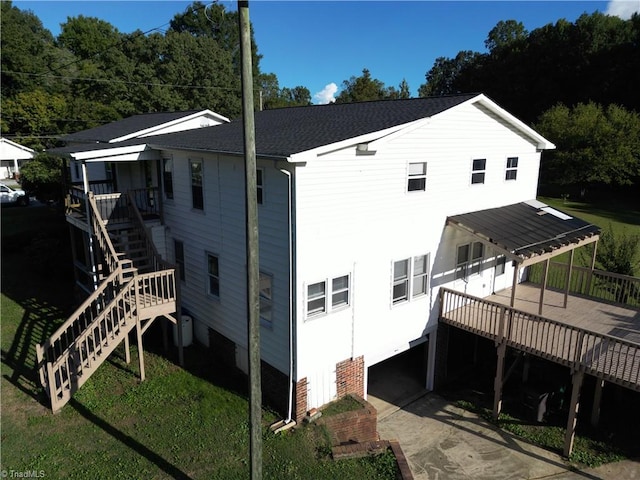 rear view of house featuring a yard and a wooden deck