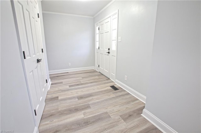 interior space with light hardwood / wood-style floors and crown molding