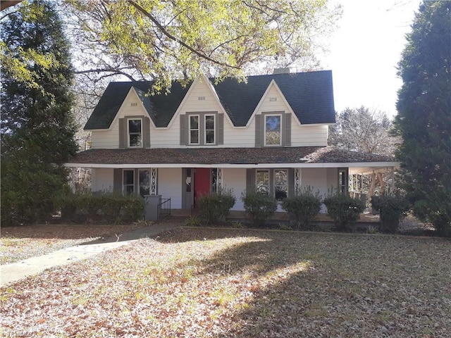 farmhouse inspired home featuring covered porch and a front yard