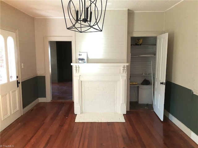 unfurnished dining area with dark wood-type flooring and a chandelier