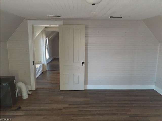 additional living space featuring dark hardwood / wood-style floors and vaulted ceiling