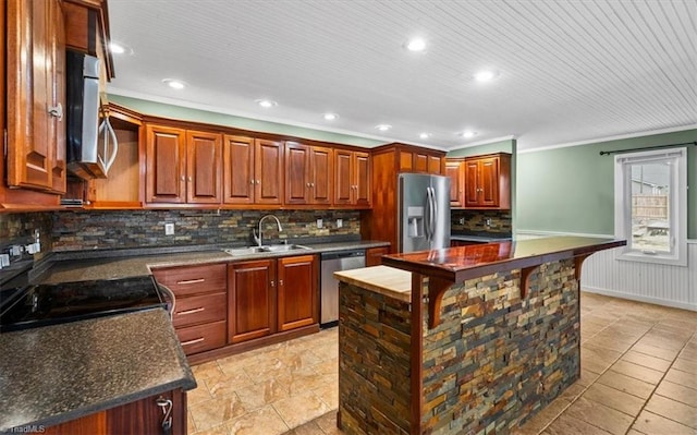 kitchen featuring a wainscoted wall, a sink, ornamental molding, appliances with stainless steel finishes, and decorative backsplash