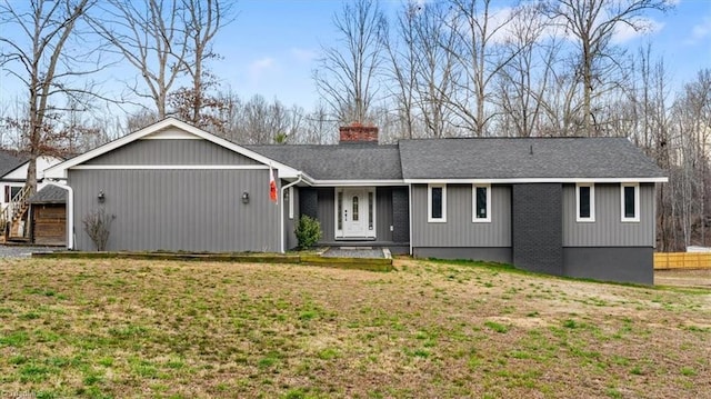 single story home with a front lawn, a chimney, and a shingled roof