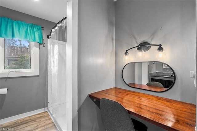 bathroom with a shower with curtain, baseboards, and wood finished floors