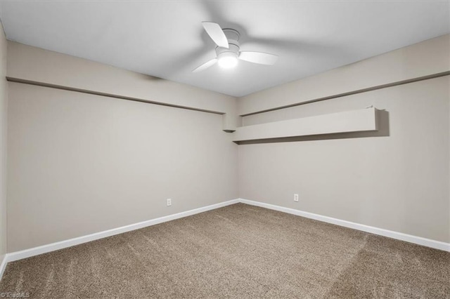 carpeted spare room with ceiling fan and baseboards