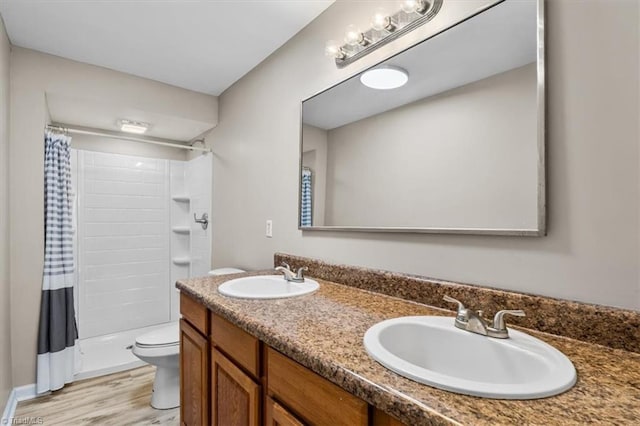 full bath featuring wood finished floors, a sink, toilet, and a shower with curtain