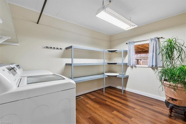 laundry room featuring laundry area, independent washer and dryer, wood finished floors, and baseboards