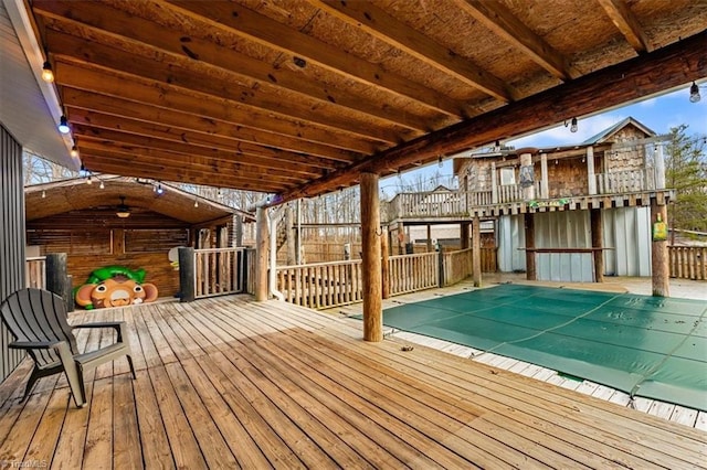 deck with a covered pool and fence