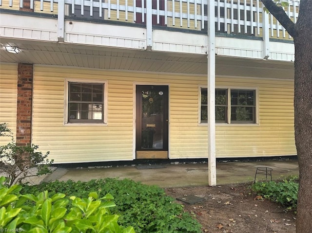 view of exterior entry with a balcony