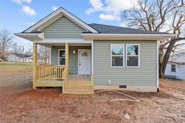 bungalow-style house with a shingled roof, crawl space, and a porch