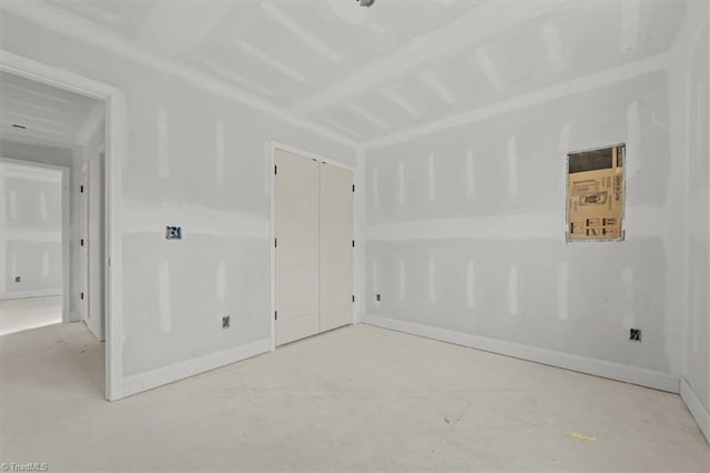 unfurnished room with baseboards