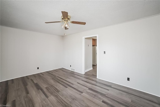 empty room with a textured ceiling, dark hardwood / wood-style floors, and ceiling fan