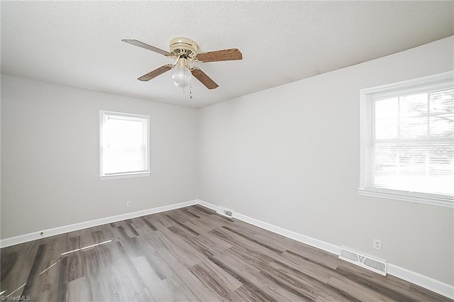 unfurnished room with ceiling fan, wood-type flooring, and a textured ceiling