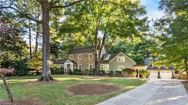 colonial inspired home featuring a garage and a front yard