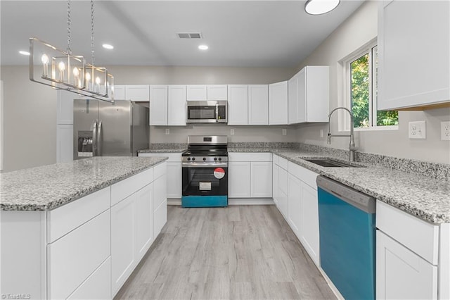 kitchen with sink, white cabinets, stainless steel appliances, and light wood-type flooring