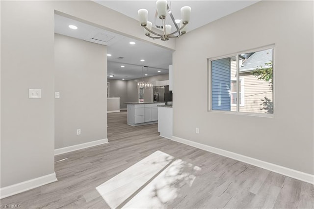 interior space featuring a notable chandelier and light hardwood / wood-style flooring