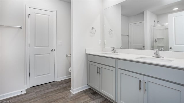 1914 Frost Dr, Haw River, NC 27258 - full bath with double vanity, toilet, wood finished floors, baseboards, and a shower with shower door