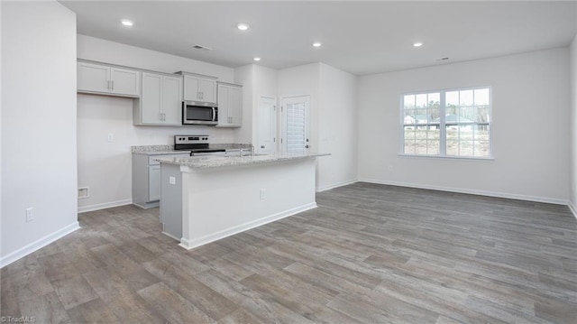 1914 Frost Dr, Haw River, NC 27258 - kitchen featuring appliances with stainless steel finishes, a sink, light wood-type flooring, a center island with sink, and recessed lighting