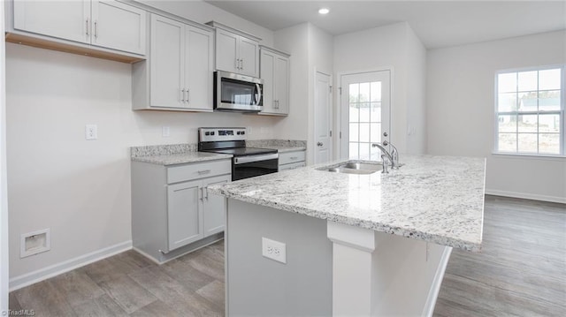 1914 Frost Dr, Haw River, NC 27258 - kitchen featuring appliances with stainless steel finishes, a sink, light wood finished floors, an island with sink, and recessed lighting