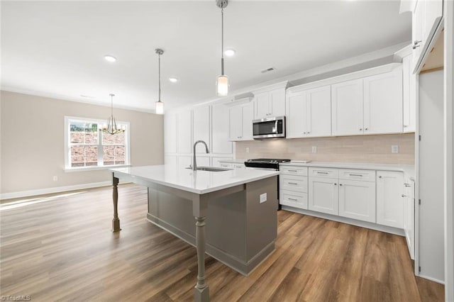 6969 Orchard Path Dr, Clemmons, NC 27012 - kitchen with appliances with stainless steel finishes, wood finished floors, decorative backsplash, white cabinets, and light countertops