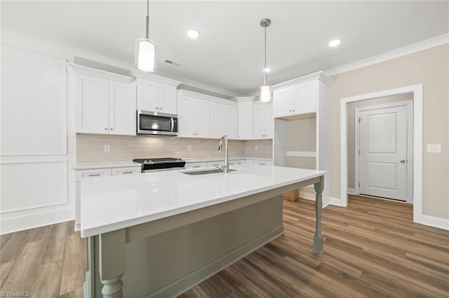 6969 Orchard Path Dr, Clemmons, NC 27012 - kitchen with stainless steel appliances, decorative backsplash, white cabinets, crown molding, and a center island with sink