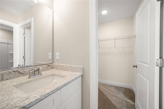6969 Orchard Path Dr, Clemmons, NC 27012 - bathroom with vanity, a walk in closet, marble finish flooring, and recessed lighting