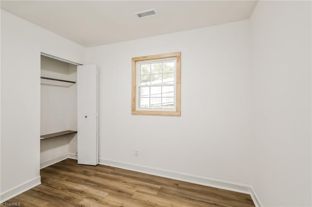 unfurnished bedroom with hardwood / wood-style floors and a closet