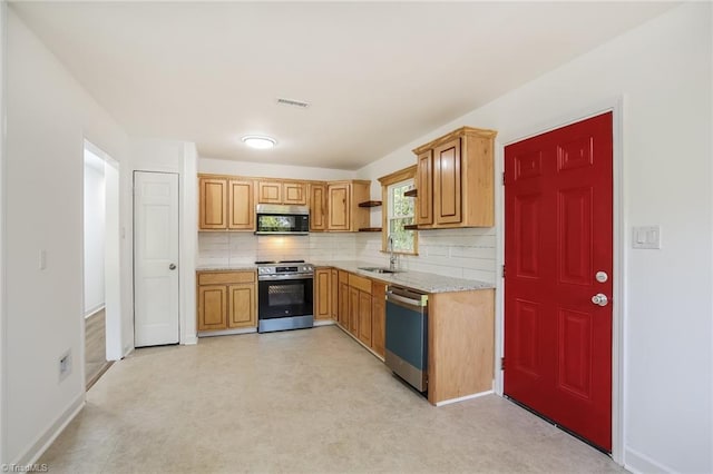 kitchen featuring sink, appliances with stainless steel finishes, and tasteful backsplash