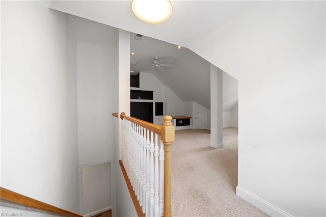 hall with baseboards, vaulted ceiling, carpet flooring, and an upstairs landing
