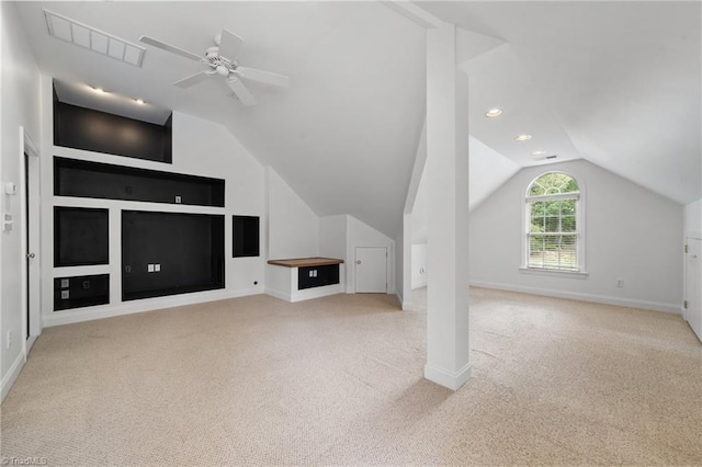 additional living space featuring carpet flooring, vaulted ceiling, baseboards, a ceiling fan, and built in shelves