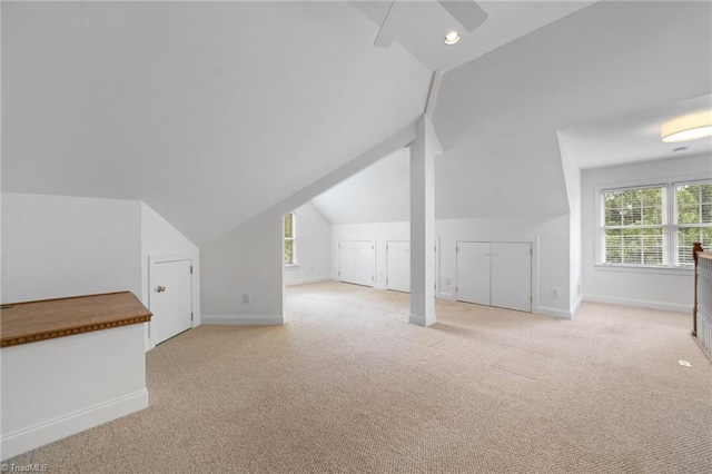 bonus room with vaulted ceiling, healthy amount of natural light, baseboards, light carpet, and recessed lighting
