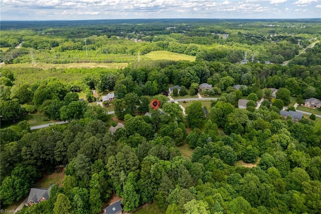 aerial view of property and surrounding area with a heavily wooded area
