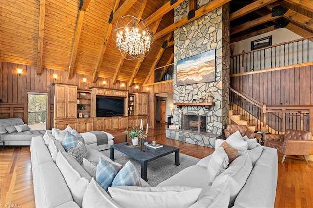 living room with wood ceiling, wooden walls, a chandelier, and a fireplace