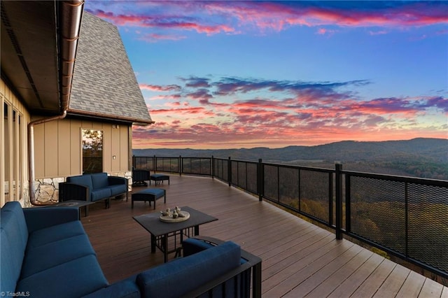 deck at dusk featuring a mountain view and an outdoor hangout area